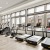 The fitness center at our apartments for rent in Prosper, featuring treadmills, bikes, and large windows.