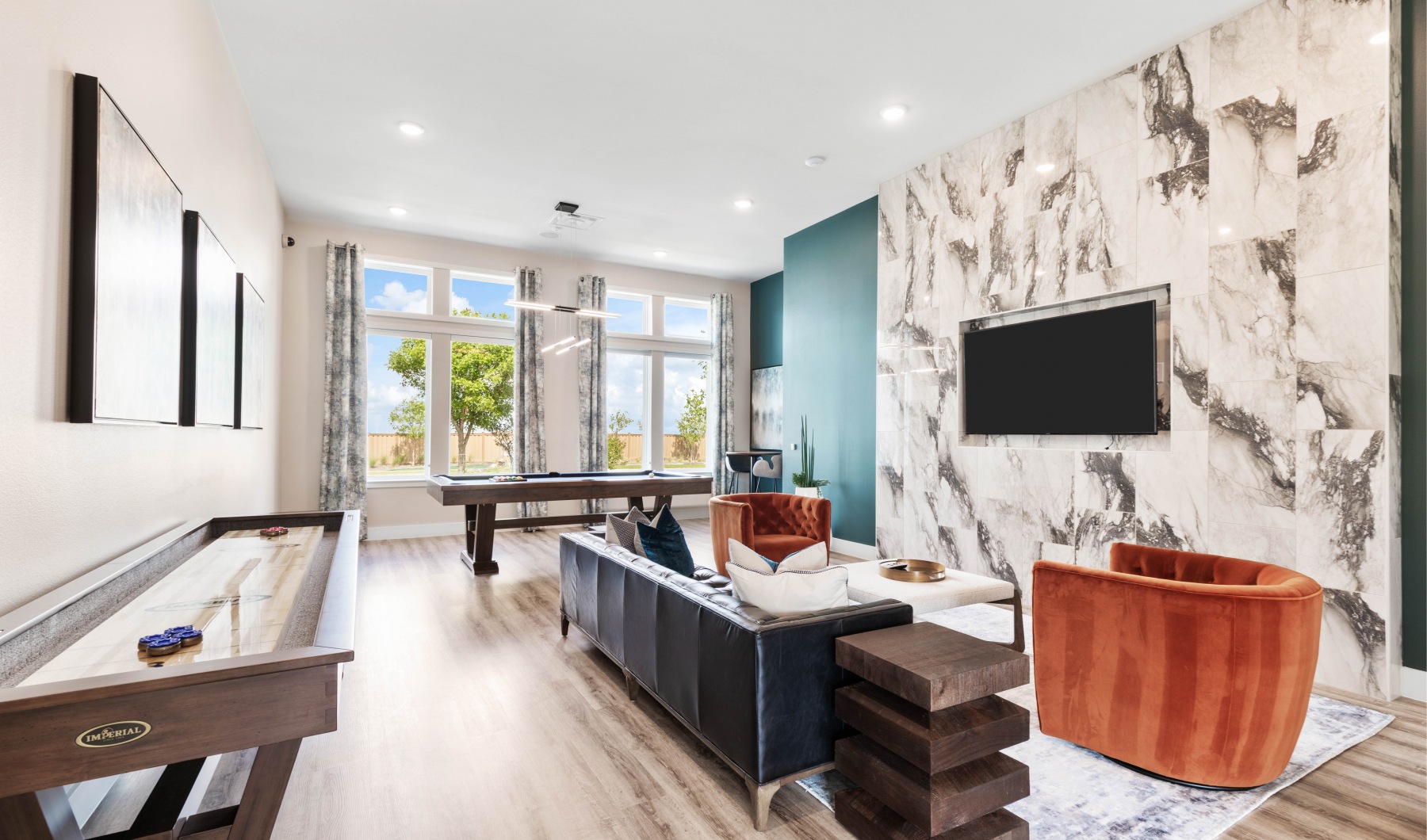 rotator Entertainment room at our apartments in Prosper, featuring a shuffleboard table, billiards, and a flat screen TV.