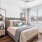 Model bedroom at our apartments for rent in Prosper, TX, featuring wood grain floor paneling and a window with blinds.