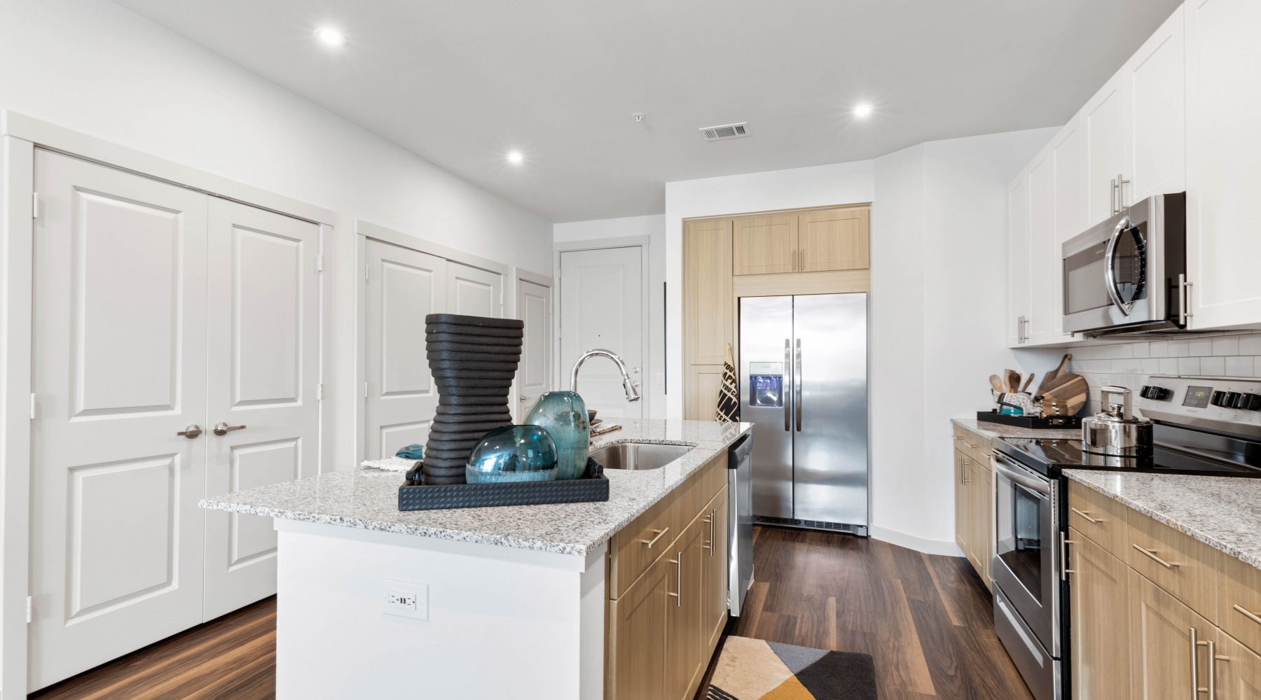 parallax Model kitchen at our apartments for rent in prosper, TX, featuring stainless steel appliances and a kitchen island.