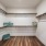 Walk in closet at our apartments for rent in Prosper, featuring wood grain floor paneling and shelving racks.